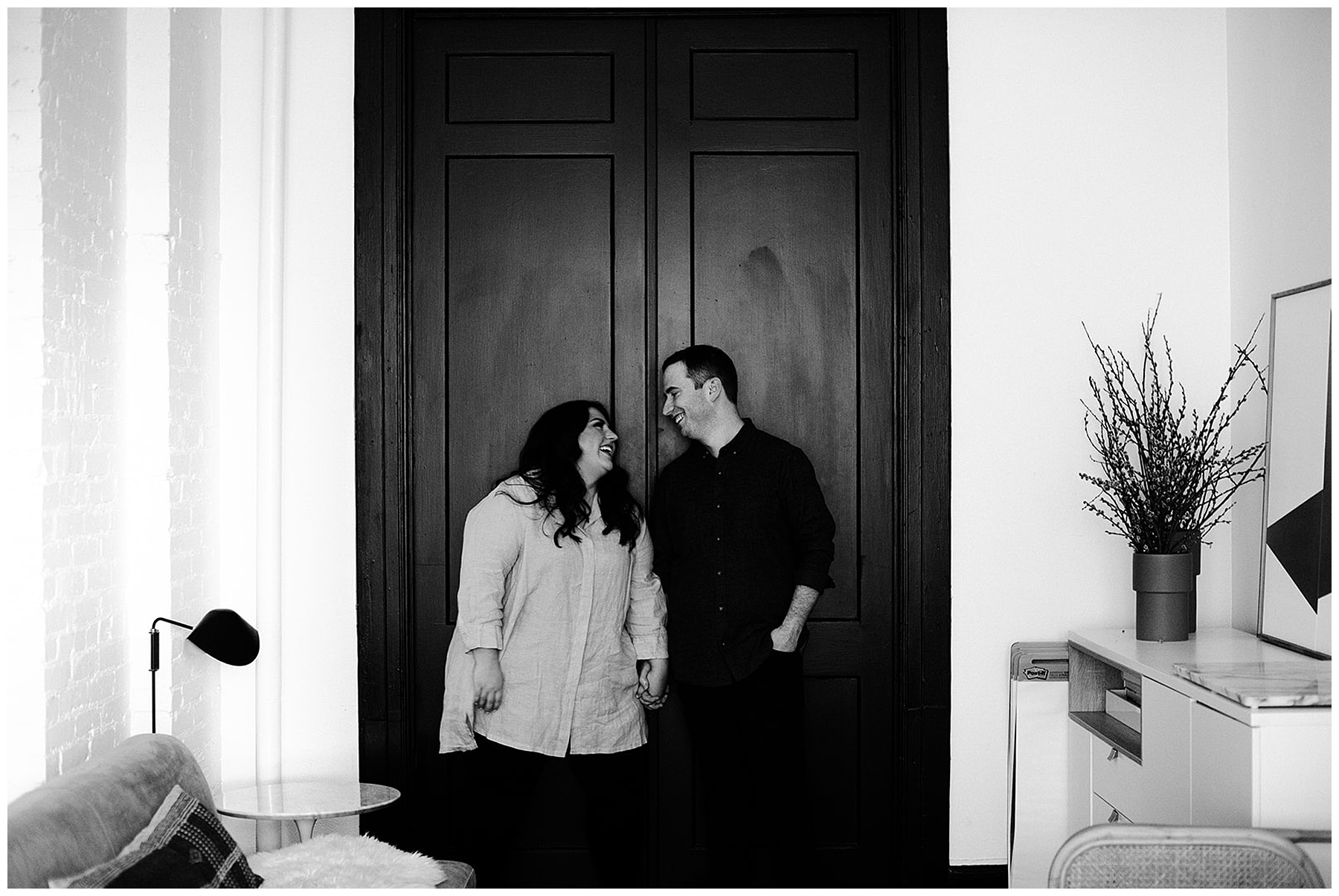 black and white photo of couple in front of door