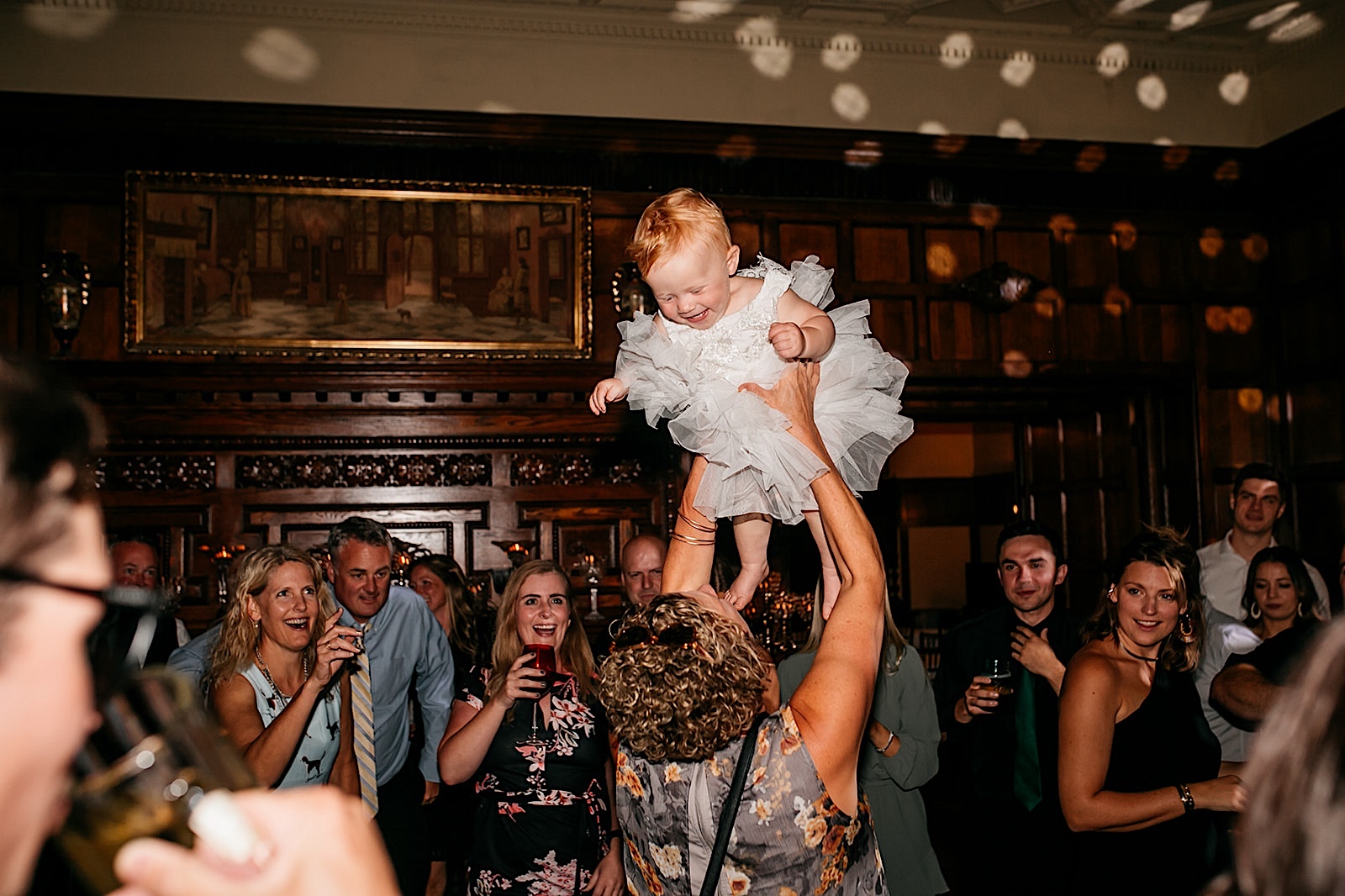 Summer wedding reception at Thornewood Castle: baby is thrown into the air during dance. 