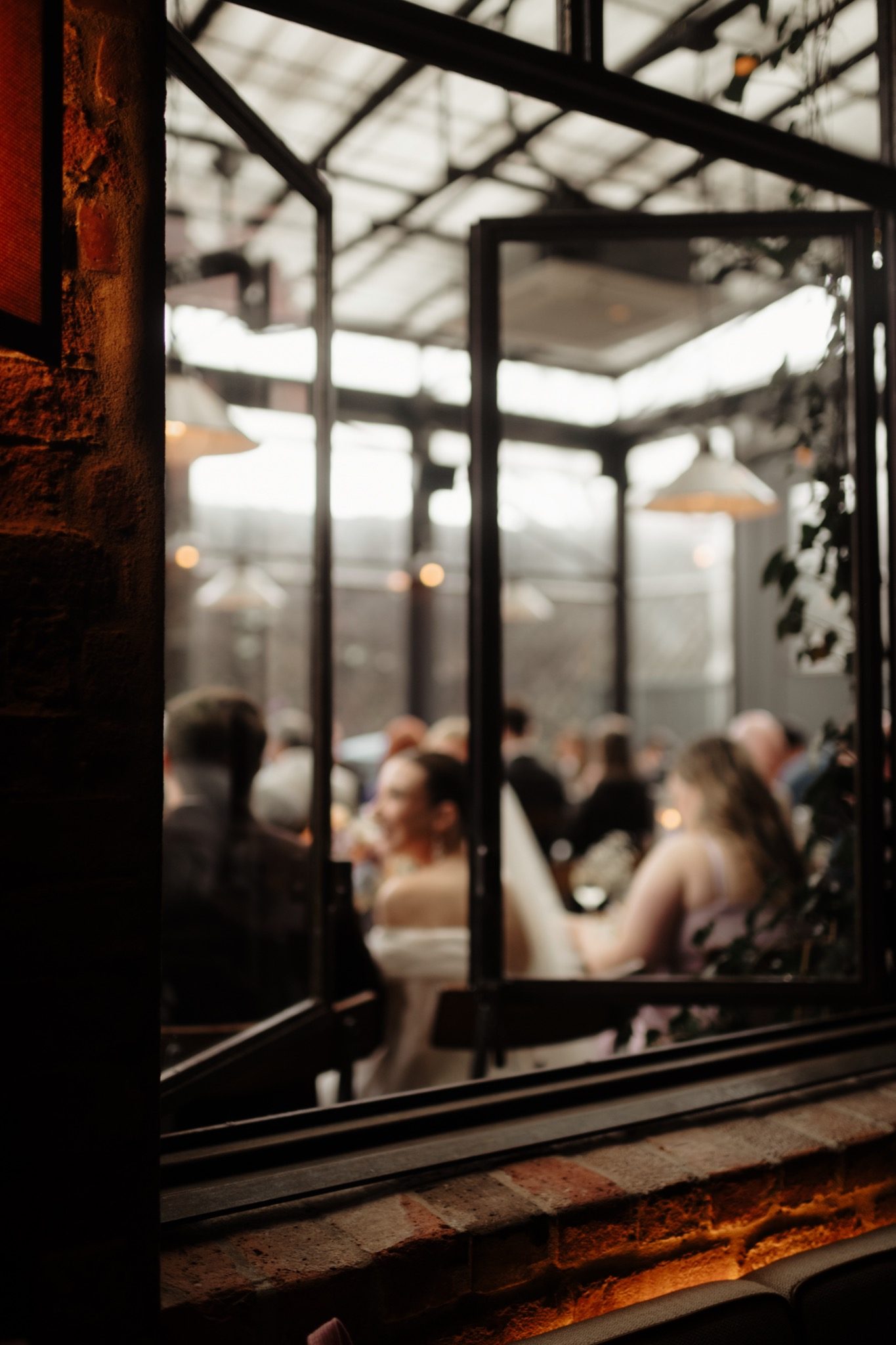 Looking into the glass room at Aurora Brooklyn during a Williamsburg wedding reception | New York wedding photographer Tonie Christine