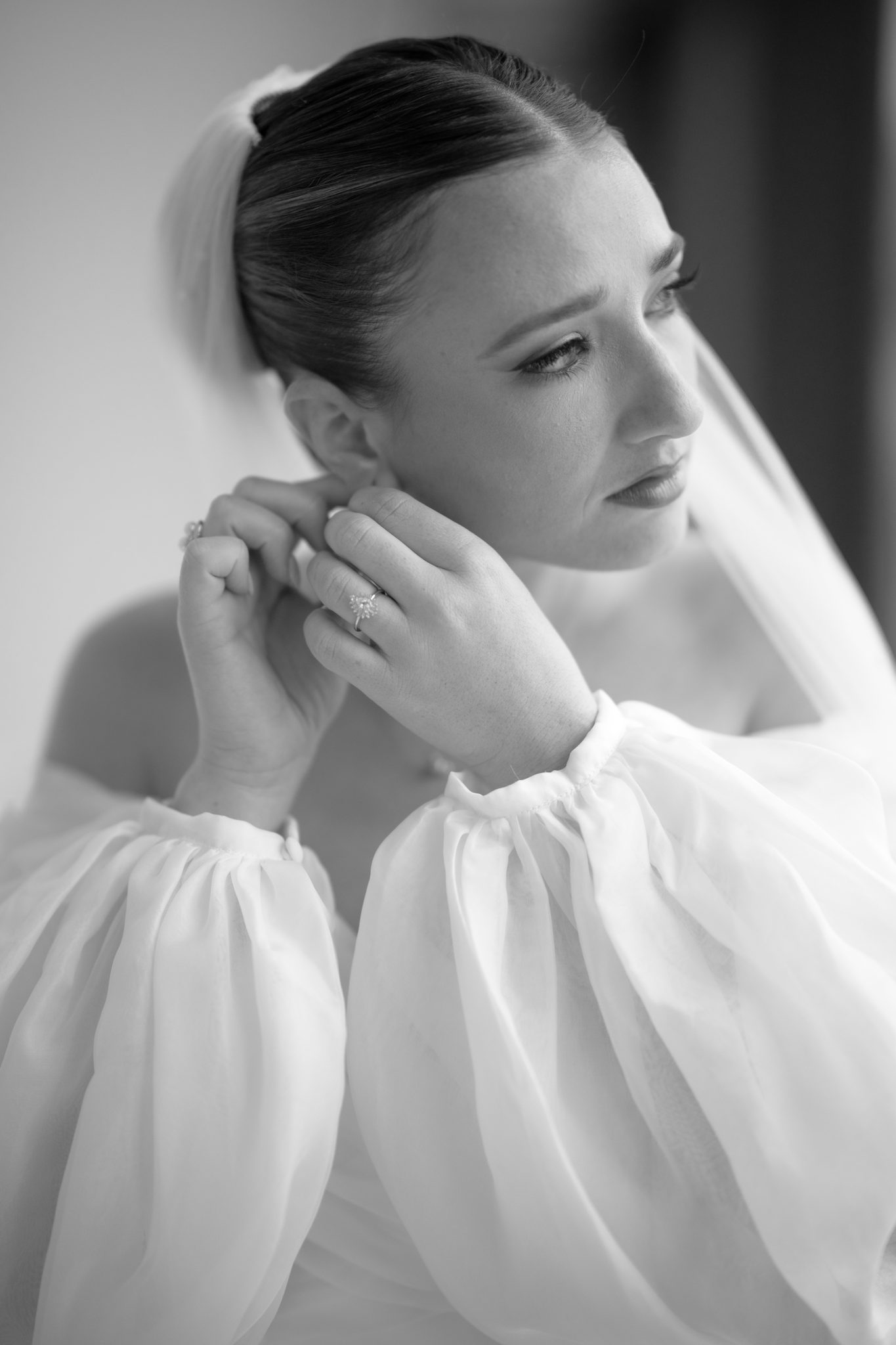 Black and white portrait of the bride putting on her earrings before her Aurora Brooklyn wedding | New York wedding photographer Tonie Christine