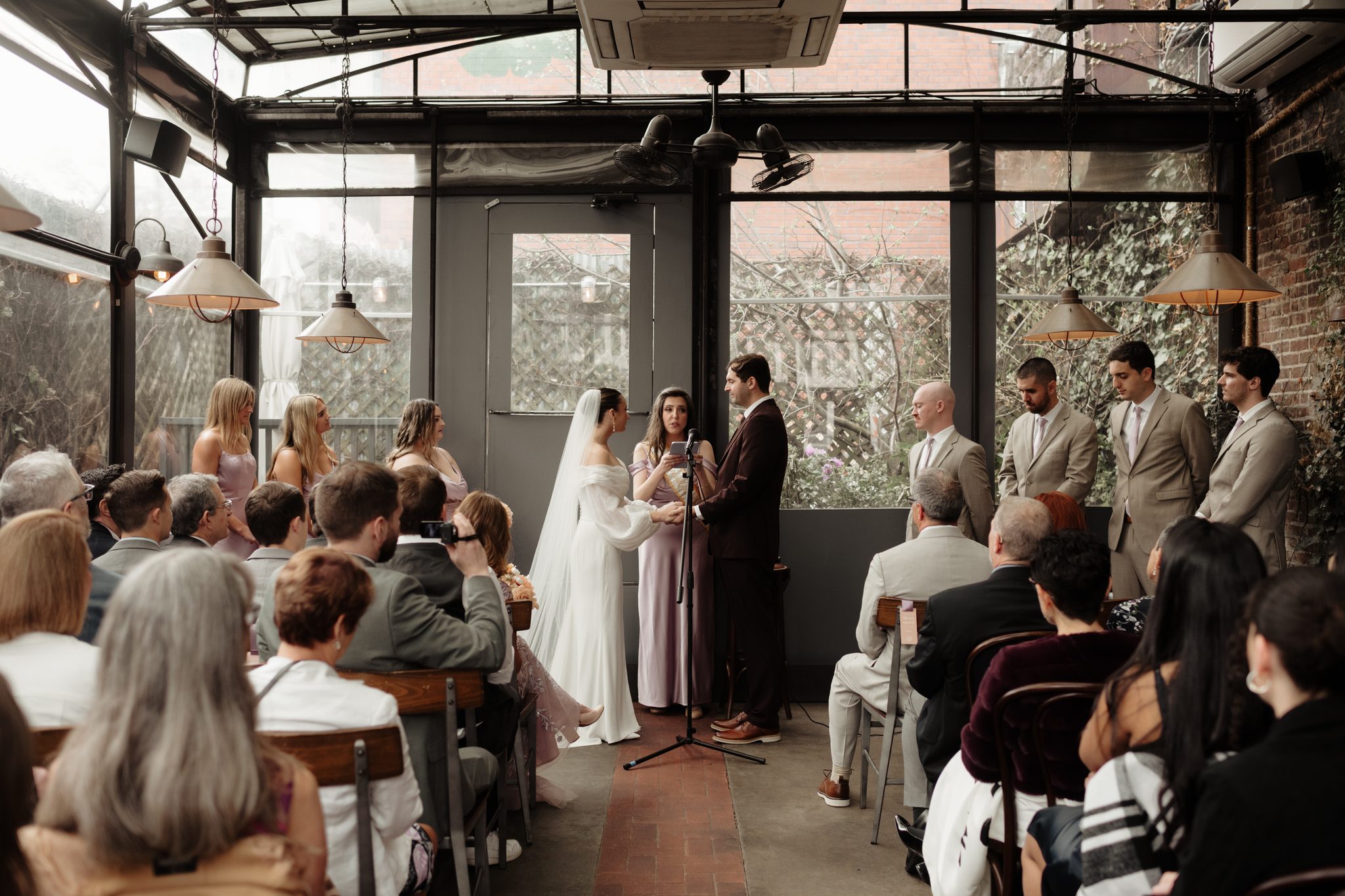 Wedding ceremony in the glass-roofed garden room at Aurora Brooklyn in Williamsburg | New York wedding photographer Tonie Christine