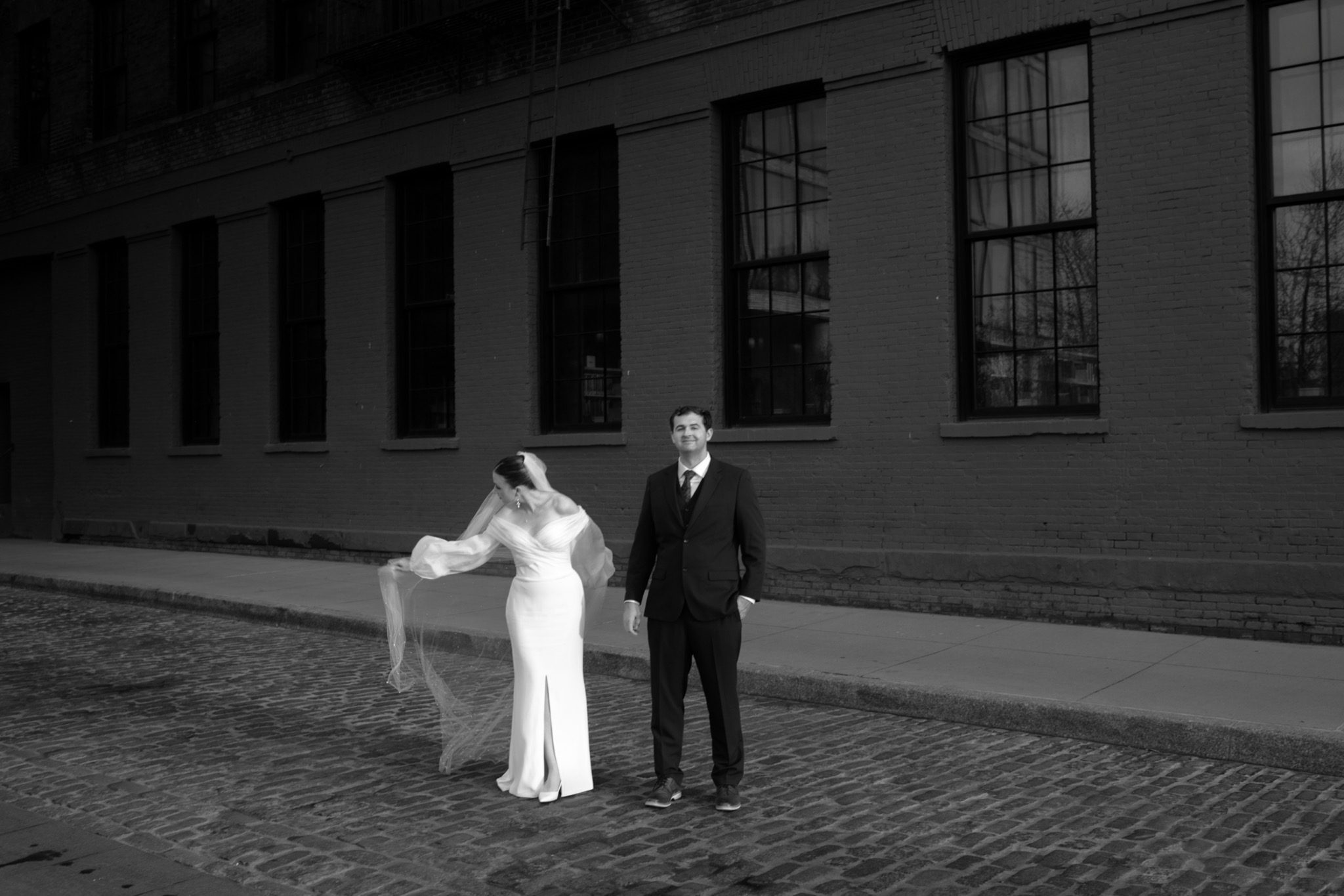 Black and white portrait of the bride and groom on the cobblestones of DUMBO, Brooklyn NYC | New York wedding photographer Tonie Christine