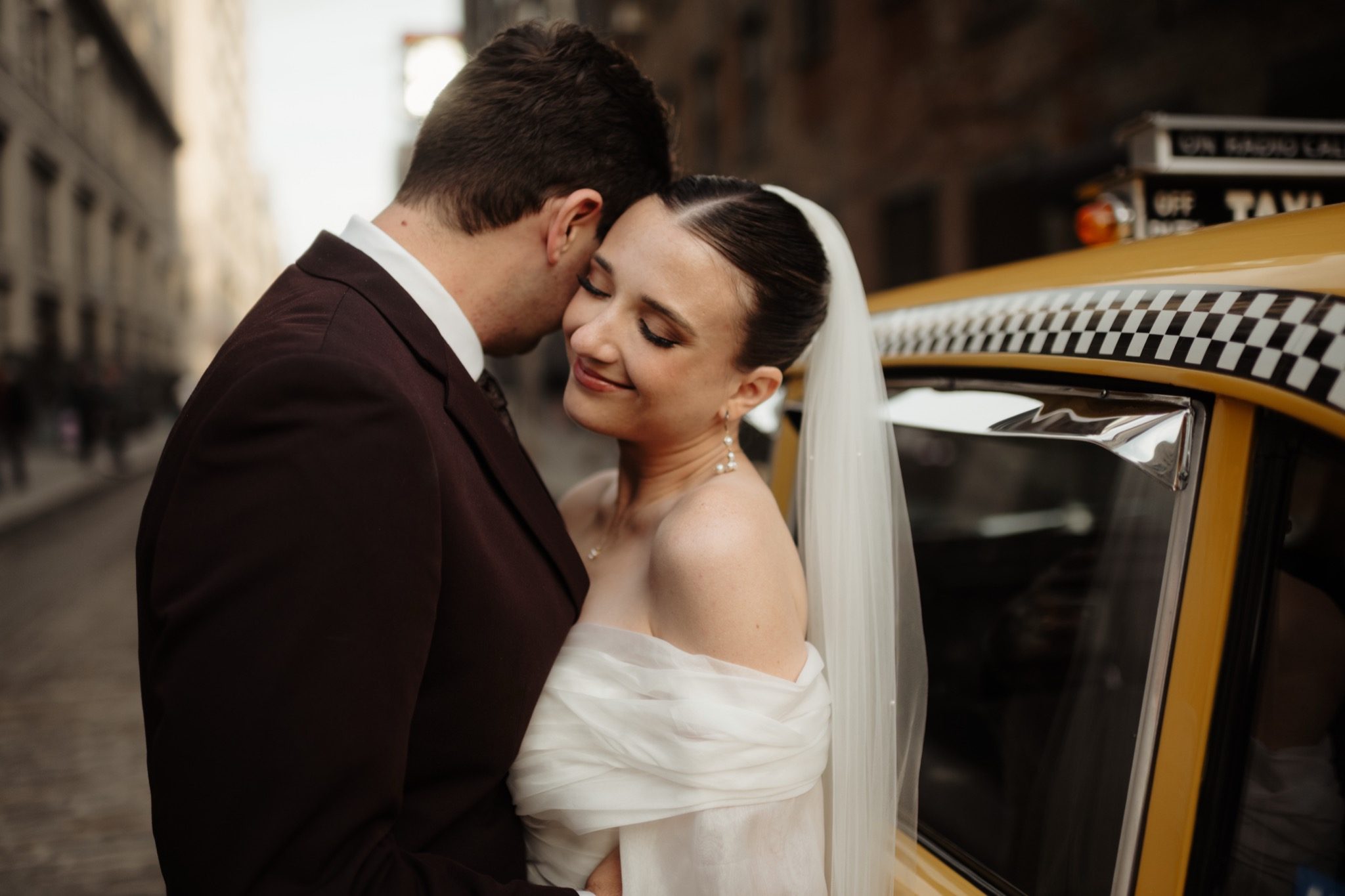 Bride and groom embracing next to a vintage yellow cab in Brooklyn, NYC | New York wedding photographer Tonie Christine