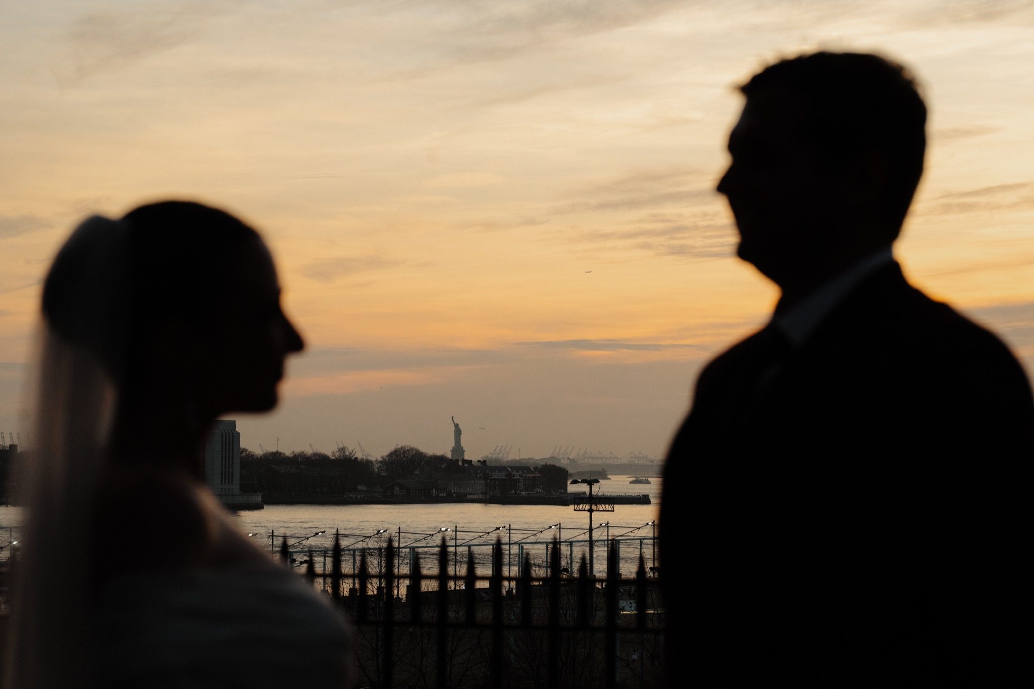 Silhouette of the bride and groom at sunset with the Manhattan skyline across the East River, Brooklyn NYC | New York wedding photographer Tonie Christine