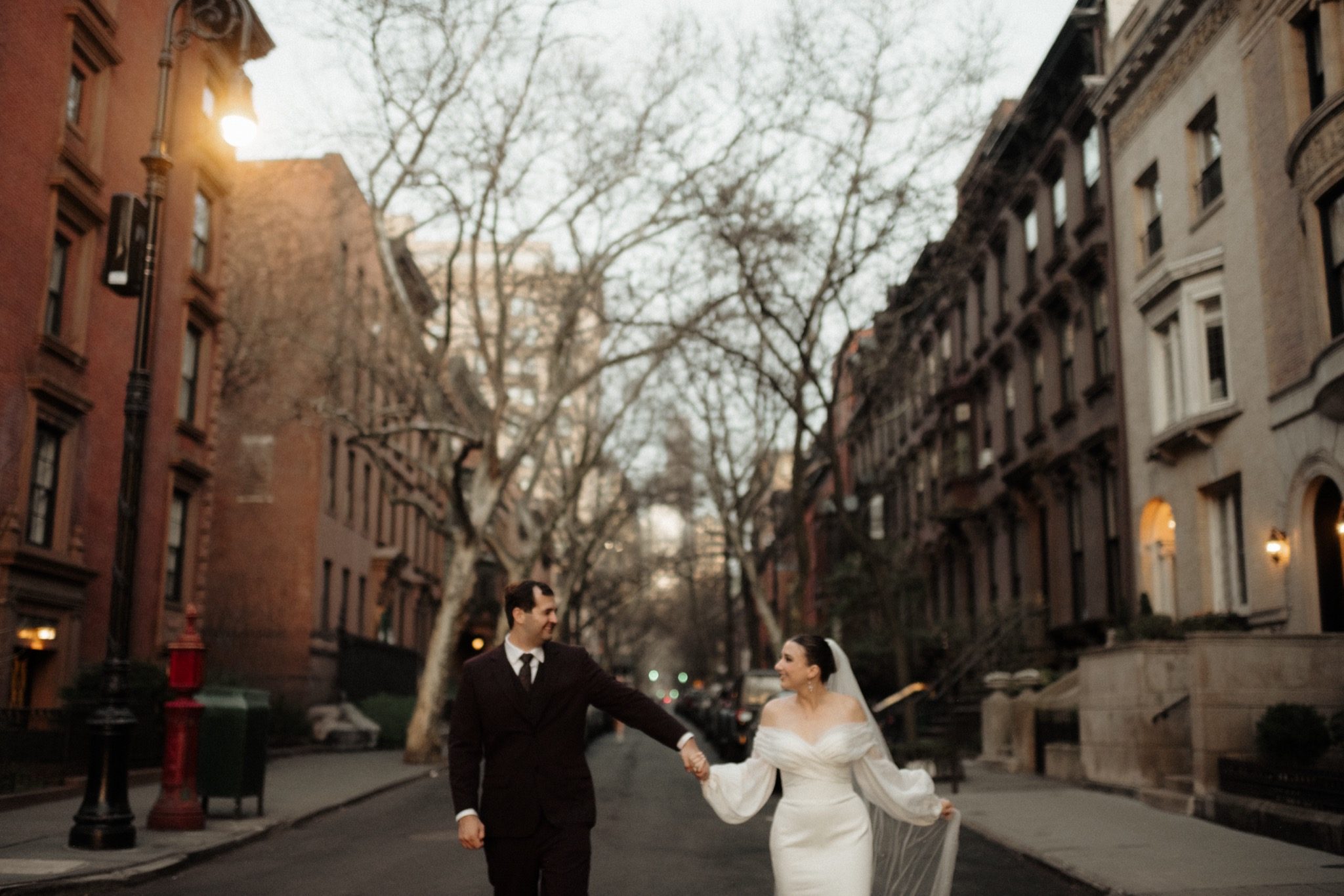 Bride and groom walking down a brownstone street in Brooklyn, NYC | New York wedding photographer Tonie Christine